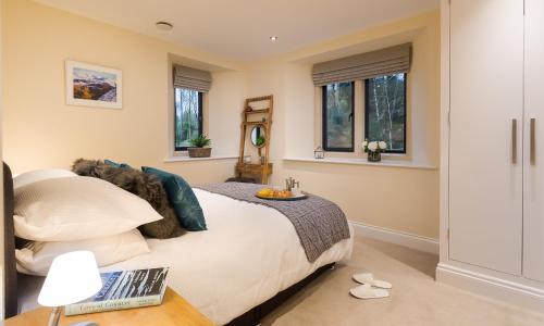 a bedroom with a bed with a laptop on a table at Mulberry At Applethwaite Hall in Windermere