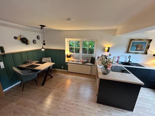 a kitchen with a table and a dining room at Appartement fliegender Hirsch in Bäk