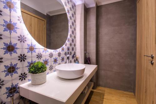 a bathroom with a sink and a mirror at Elysian Rose Residence in Rethymno