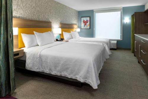 a hotel room with two beds and a window at Home2 Suites By Hilton Buford Mall Of Georgia, Ga in Buford
