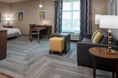 a hotel room with a bed and a couch at Homewood Suites By Hilton Greensboro Wendover, Nc in Greensboro