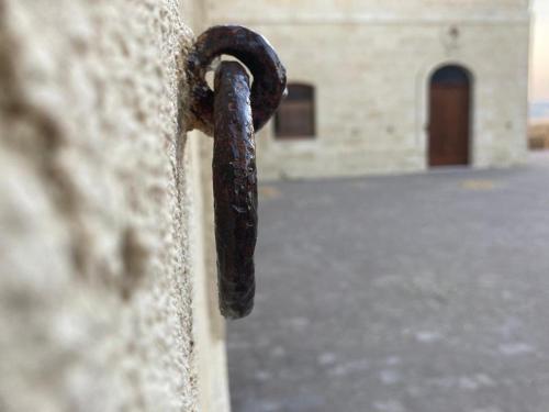 a rusty chain attached to a stone wall at La Commenda di Picciano - Country House in Matera