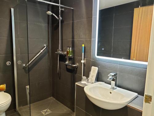 a bathroom with a shower and a sink and a toilet at Bingham Townhouse Hotel in Bingham