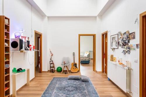 uma sala de estar com um tapete e uma sala com uma guitarra em Affittacamere Pagoda RECANATI em Recanati
