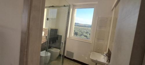 baño con ventana, aseo y lavamanos en La Commenda di Picciano - Country House, en Matera