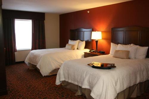 Habitación de hotel con 2 camas y bandeja de comida en Hampton Inn and Suites Peru en Peru