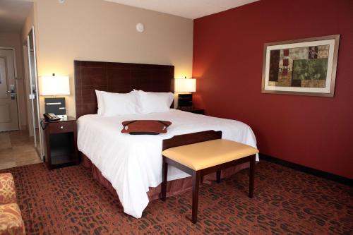 a hotel room with a large bed and a table at Hampton Inn Milan in Milan