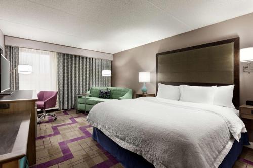 une chambre d'hôtel avec un lit et une chaise dans l'établissement Hampton Inn Waycross, à Waycross
