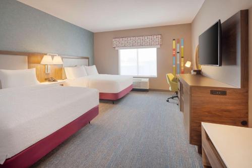 ein Hotelzimmer mit 2 Betten und einem Flachbild-TV in der Unterkunft Hampton Inn Clovis, Nm in Clovis