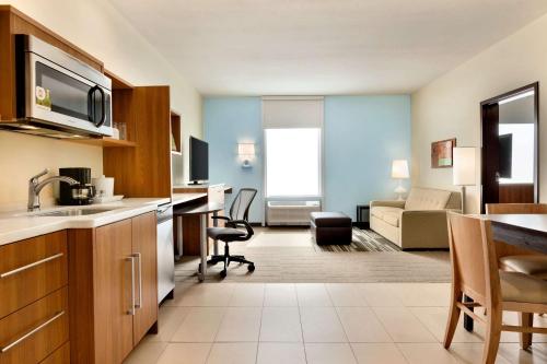 uma cozinha e sala de estar num quarto de hotel em Home2 Suites by Hilton Edmond em Edmond