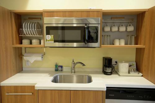 a kitchen with a sink and a microwave at Home2 Suites by Hilton Edmond in Edmond