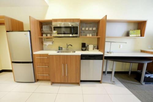 a kitchen with a sink and a refrigerator at Home2 Suites by Hilton Edmond in Edmond