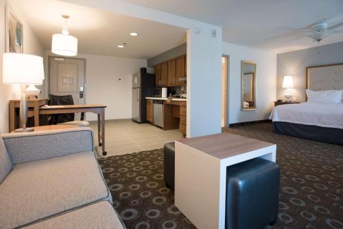 パデューカにあるHomewood Suites By Hilton Paducahのベッドとリビングルームが備わるホテルルームです。