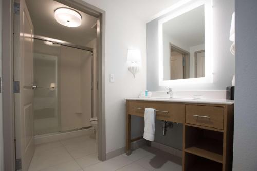 y baño con lavabo y ducha con espejo. en Homewood Suites By Hilton Paducah, en Paducah