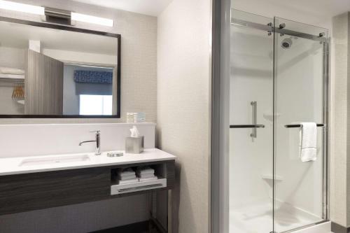 a bathroom with a sink and a shower with a mirror at Hampton Inn & Suites St Charles Old Town Area, Mo in St. Charles