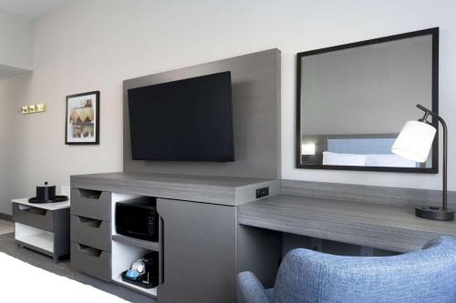 a living room with a tv and a blue chair at Hampton Inn & Suites St Charles Old Town Area, Mo in St. Charles