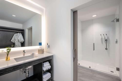 a bathroom with a sink and a shower at Holman Riverfront Park Hotel Salem, Tapestry By Hilton in Salem