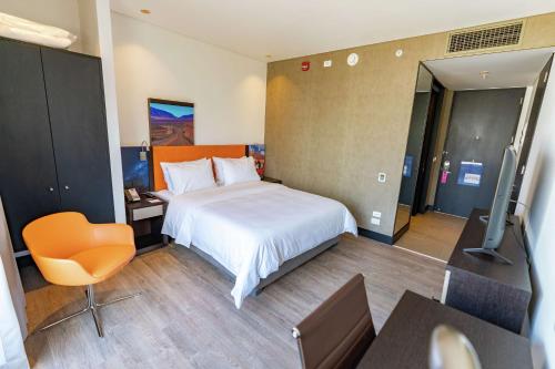 a bedroom with a bed and a desk and a television at Hampton By Hilton Antofagasta in Antofagasta