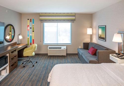 a hotel room with a bed and a couch at Hampton Inn Columbus in Columbus