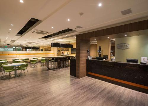 een lobby met een bar en een aantal tafels en stoelen bij Hampton by Hilton Barranquilla in Barranquilla