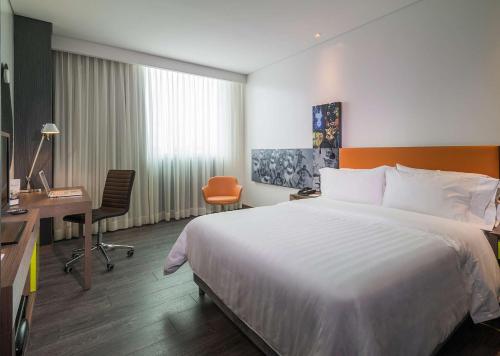 a hotel room with a bed and a desk at Hampton by Hilton Barranquilla in Barranquilla