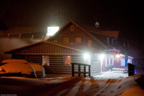a house at night with snow and lights on it at Pension Modrá Hvězda in Dolní Malá Úpa