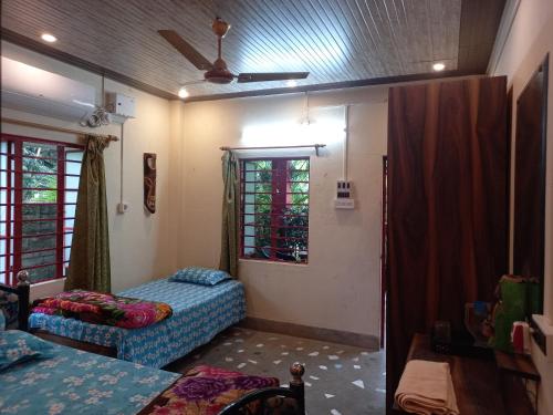 um quarto com uma cama, um sofá e uma janela em Atmaja The Cottage Garden Home Stay Malda Under Tourism Department Government of West Bengal em Māldah
