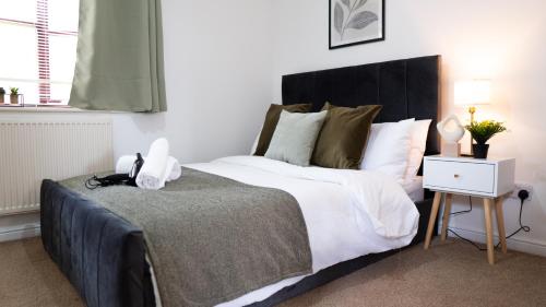 a bedroom with a large bed with a black headboard at The Cosy Corner in Loughton