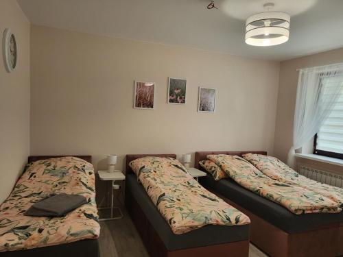 1 dormitorio con 2 camas, mesa y ventana en Zestaw rodzinny, en Żyrardów