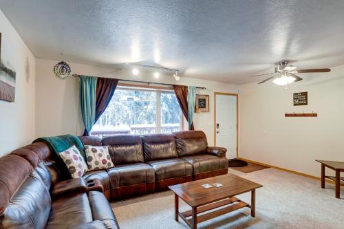 a living room with a leather couch and a table at Peaceful Nature Escape with Deck in North Pole! in North Pole
