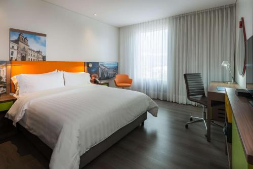 Habitación de hotel con cama, escritorio y ordenador en Hampton By Hilton Bogota Airport en Bogotá