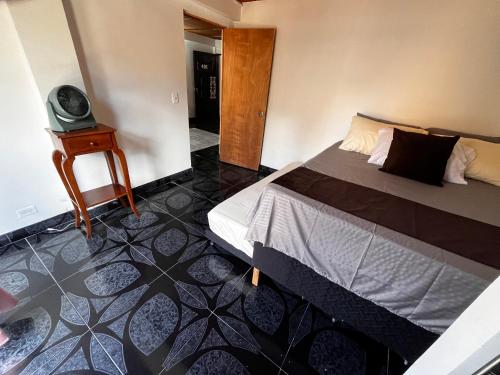ein Schlafzimmer mit einem Bett und einem kleinen Tisch in der Unterkunft Aparta Suite Torre De Prado 401 in Medellín