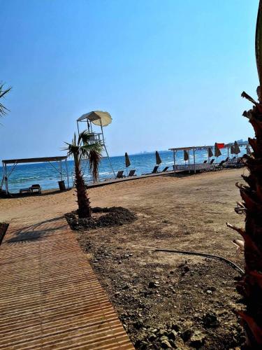 a beach with chairs and umbrellas and the ocean at Sunrise Beach Club (Hera B6@) in Kalecik