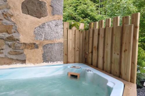 una bañera de hidromasaje en un patio trasero con una valla de madera en Chalet de Creytoral en Arâches-la-Frasse