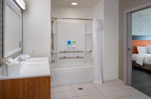 y baño con ducha, lavabo y bañera. en Home2 Suites St. Louis / Forest Park, en Richmond Heights