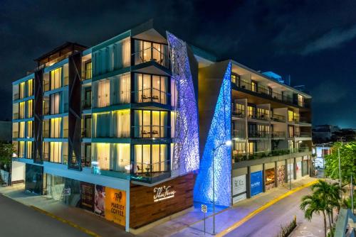 a building with blue lights on it at night at The Fives Downtown Hotel & Residences, Curio Collection by Hilton in Playa del Carmen