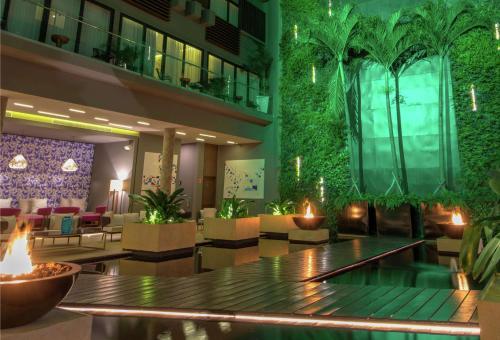 a lobby of a hotel with a green wall at The Fives Downtown Hotel & Residences, Curio Collection by Hilton in Playa del Carmen
