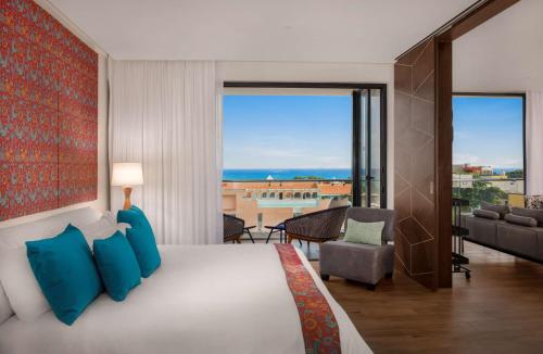 a bedroom with a bed and a view of the ocean at The Fives Downtown Hotel & Residences, Curio Collection by Hilton in Playa del Carmen