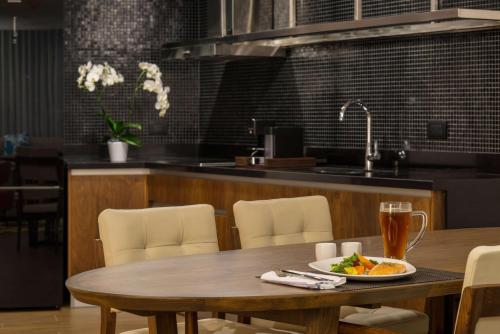 a table with a plate of food and a drink on it at The Fives Downtown Hotel & Residences, Curio Collection by Hilton in Playa del Carmen