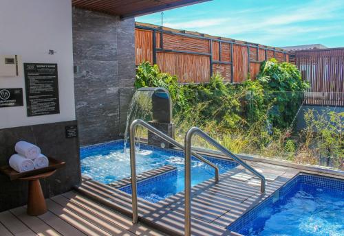 a plunge pool with stairs next to a house at The Fives Downtown Hotel & Residences, Curio Collection by Hilton in Playa del Carmen