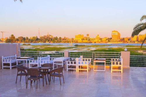 a group of tables and chairs on a patio at Royal Nile Villa - Nile View Apartment 1 in Luxor
