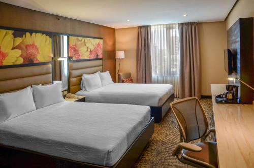 a hotel room with two beds and a television at Hilton Garden Inn Guatemala City in Guatemala