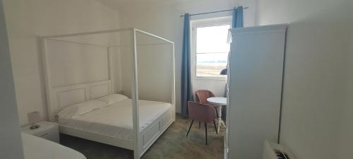 1 dormitorio con cama blanca y espejo en La Commenda di Picciano - Country House, en Matera