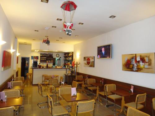 a restaurant with tables and chairs in a room at Hotel del Sol in La Plata