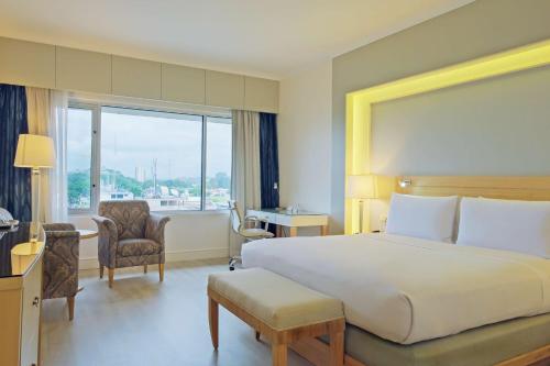 a hotel room with a large bed and a large window at Hilton Colon Guayaquil Hotel in Guayaquil