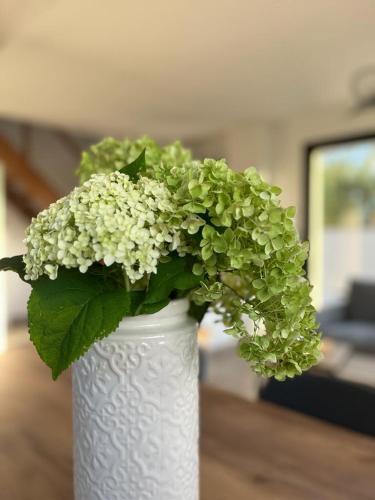 un vase blanc avec une plante verte dans l'établissement La vie est belle, à Ryes