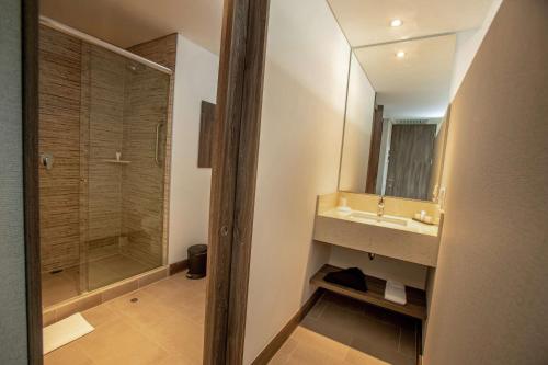 a bathroom with a shower and a sink and a mirror at Hampton By Hilton Lima San Isidro in Lima