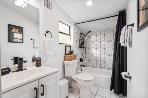 a white bathroom with a toilet and a sink at Quiet get away in a vibrant city in St. Augustine