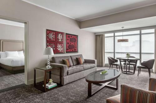 a living room with a couch and a bed and a table at DoubleTree by Hilton Lima Miraflores El Pardo in Lima