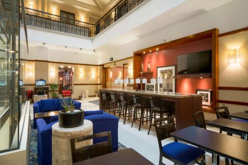 a restaurant with tables and chairs and a bar at Hampton Inn & Suites Mexico City - Centro Historico in Mexico City